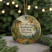 A decorative ornament featuring a scenic landscape with a path, trees, and a cliff, hanging from a string.