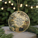 A round ornament with a vintage-style illustration of a historic park, featuring a horse, typewriter, and other elements, hanging from a string.