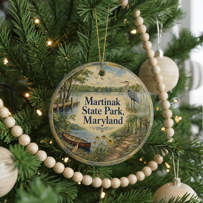 A round ornament hanging on a Christmas tree, featuring a scenic image of Martinak State Park, Maryland.
