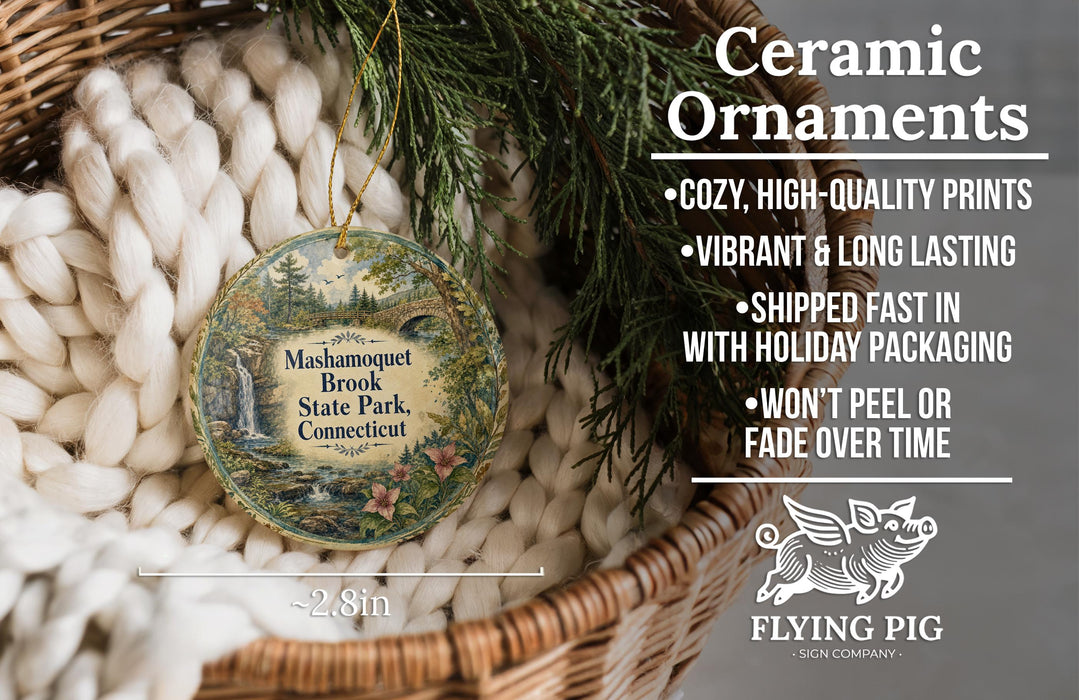 Ceramic ornaments, including a round ornament with a scenic image of Mashamquet Brook State Park, Connecticut, hanging from a wicker basket.