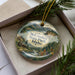 A decorative ornament with a scenic landscape of mountains, trees, and a river, featuring the text "McRoskey State Park, Idaho" on it.