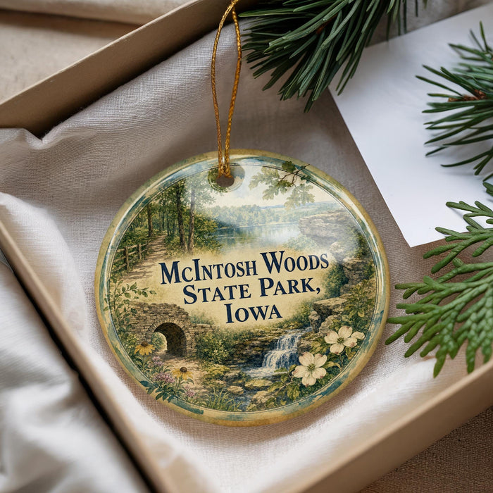 A decorative ornament with a scenic image of a forest and a waterfall, featuring the text "McIntosh Woods State Park, Iowa".