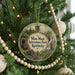 A circular ornament hanging on a Christmas tree, featuring a scenic illustration of Kentucky with a sign that says " Mine Made Adventure Park, Kentucky".