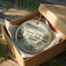 A decorative ornament in a wooden box, featuring a moose and a scenic landscape, with the text "Moose Point State Park, Maine" on it.