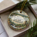 A decorative ornament in a box, featuring a scenic landscape of Mount Washington State Forest in Massachusetts.