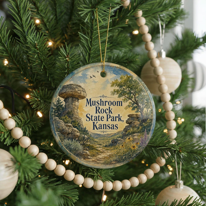 A round ornament hanging on a Christmas tree, featuring a scenic landscape with a mushroom-shaped rock formation and a path leading through the field.