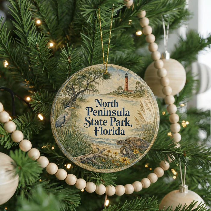 A round ornament hanging on a Christmas tree, featuring a scenic image of the North Peninsula State Park in Florida.