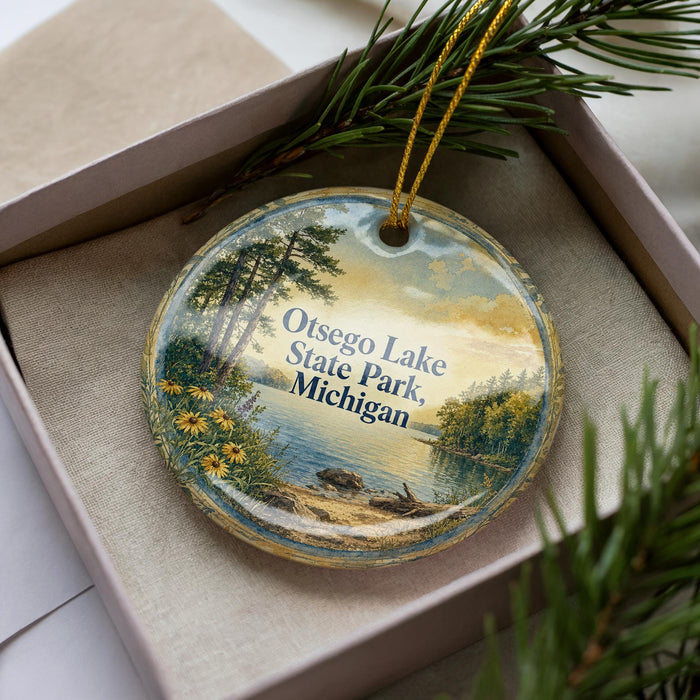 A decorative ornament with a scenic landscape of Osego Lake, Michigan, featuring a lake, trees, and a sunset.