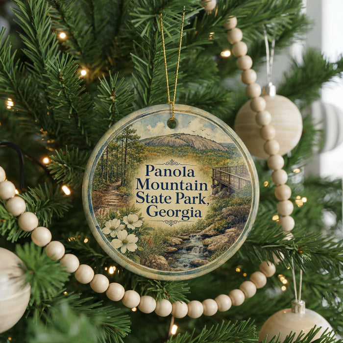 A round ornament hanging on a Christmas tree, featuring a scenic image of Panola Mountain State Park in Georgia.
