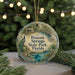 A circular ornament with a peacock and a scenic view of the springs and state park in Florida, hanging from a string.