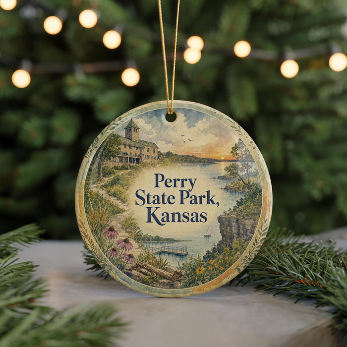 A round ornament with a painting of Perry State Park, Kansas, hanging from a string.