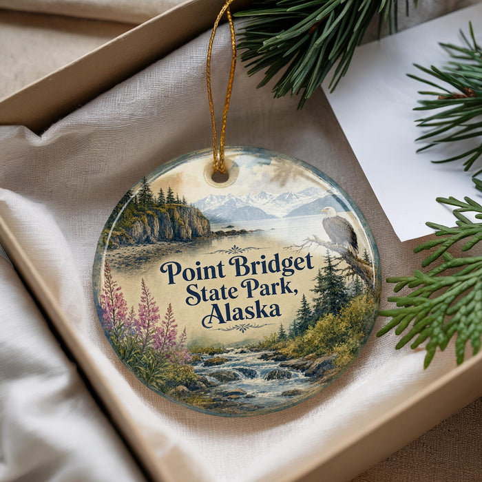 A decorative ornament with a scenic landscape of Point Bridget State Park, Alaska, featuring a mountain range, pine trees, and a waterfall.