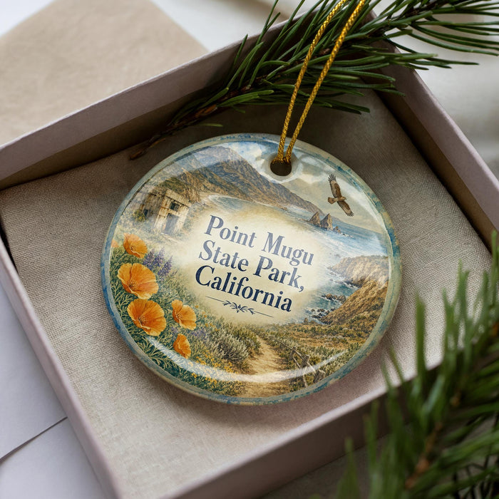 A decorative ornament in a box, featuring a scenic landscape with a path, flowers, and a bird in flight.