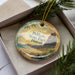 A decorative ornament in a box, featuring a scenic image of Polihale State Park in Hawaii.
