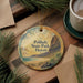 A round ornament with a scenic image of Polihale State Park in Hawaii, featuring a beach, mountains, and palm trees.
