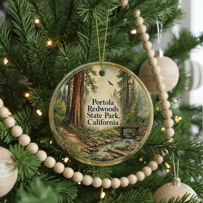 A round ornament hanging on a Christmas tree, featuring a scenic image of Portola Redwoods State Park, California.