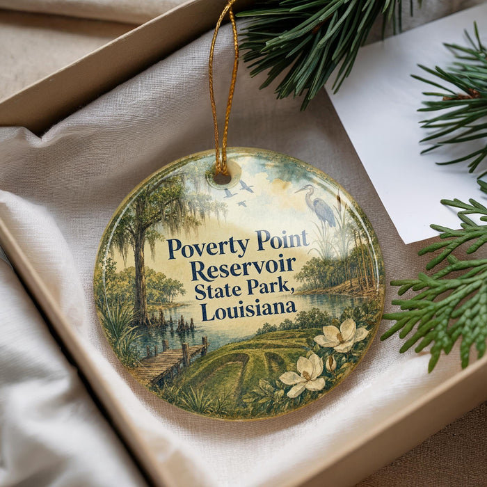 A decorative ornament with a landscape scene featuring a pond, trees, and a bird, hanging from a string.