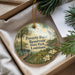 A decorative ornament with a landscape scene featuring a pond, trees, and a bird, hanging from a string.
