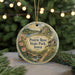 A decorative ornament featuring a scenic landscape with a path leading to a house, surrounded by greenery and flowers.