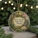A circular ornament with a scenic illustration of a park, featuring a waterfall, flowers, and greenery, hangs in front of a blurred background of trees and lights.