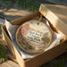 A decorative ornament in a box, featuring a scenic image of the Red Rock Canyon State Park in California.