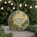 A round ornament with a scenic landscape of Reed Bingham State Park, Georgia, featuring a waterfall and pine trees, is displayed on a table with a blurred background of Christmas lights.