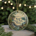 A circular ornament with a scenic landscape of Reid State Park, Maine, featuring a waterfall, pine trees, and mountains.