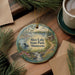 A decorative ornament featuring a scenic landscape of Rice Lake State Park in Minnesota, with a bird, flowers, and a waterfall.