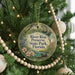A round ornament hanging on a Christmas tree, featuring illustrations of a bird, a deer, and flowers, with the text "River Rise Preserve State Park, Florida" displayed on it.