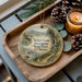 A wooden tray with a decorative ornament featuring a scenic landscape, including mountains, a river, and pine trees. The ornament also includes the text "Robert Louis Stevenson State Park, California".