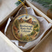 A decorative ornament in a box, featuring a scenic landscape with mountains, a bird, and flowers, with the text "Roxborough State Park, Colorado" printed on it.
