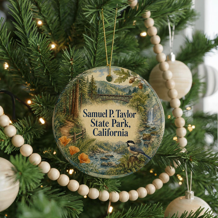 A Christmas tree decorated with ornaments, including a round ornament with a scenic image of Samuel P. Taylor State Park, California.