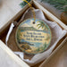 A circular ornament with a beach scene and palm trees, featuring the text "Sand Island State Recreation Area, Hawaii" on it.
