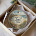 A round ornament in a box, featuring a lighthouse and a coastal scene, with the text "ScARBOROUGH BEACH STATE PARK, MAINE" printed on it.