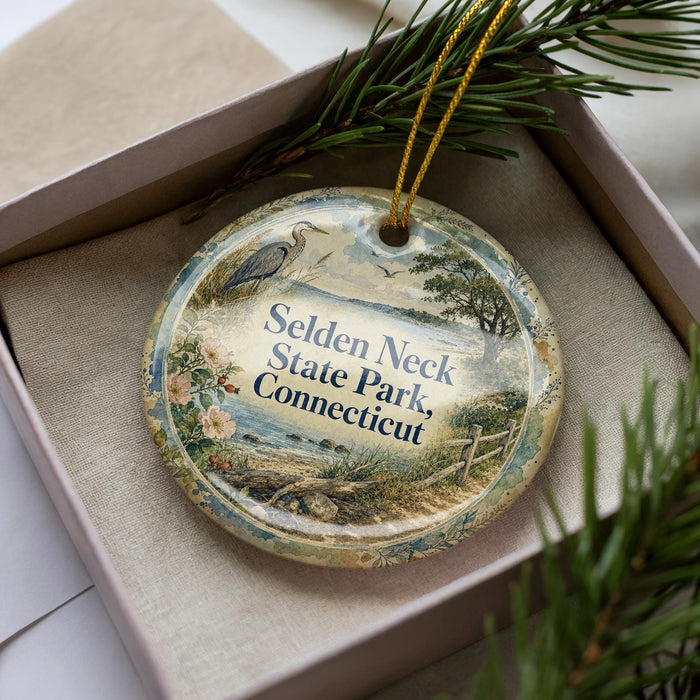 A decorative ornament in a box, featuring a scenic landscape with a bird and trees, along with the text "SELDEN NECK STATE PARK, CONNECTICUT".