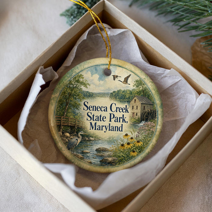 A decorative ornament in a box, featuring a scenic image of Seneca Creek State Park, Maryland.