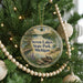 A circular ornament hanging on a Christmas tree, featuring a scenic image of Seven Lakes State Park in Michigan.