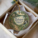 A circular ornament with a scenic landscape of Shokamak State Park, Indiana, displayed in a box with a white tissue paper lining.