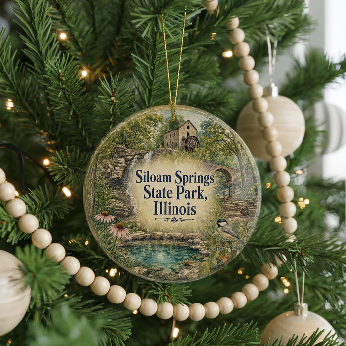 A round ornament hanging on a Christmas tree, featuring a scenic image of Siloam Springs State Park, Illinois.