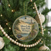A round ornament hanging on a Christmas tree, featuring a scenic image of Silver Lake State Park, Michigan.