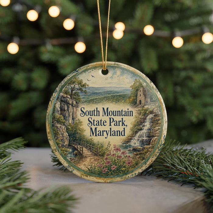 A round ornament with a scenic landscape of South Mountain State Park, Maryland, featuring a waterfall, a bridge, and a forest.