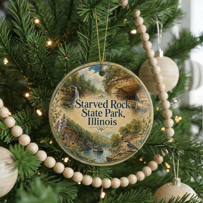 A round ornament hanging on a Christmas tree, featuring a scenic image of the Starved Rock State Park in Illinois.