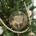 A round ornament hanging on a Christmas tree, featuring a scenic image of Stephen C. Foster State Park, Georgia.