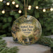 A decorative ornament featuring a scenic landscape with a waterfall, cabin, and deer, hanging from a string.