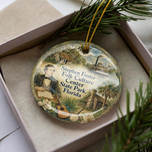 A round ornament with a picture of a man and text, placed in a box with pine branches.