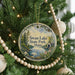 A round ornament hanging on a Christmas tree, featuring a scenic image of Swan Lake State Park in Maine.