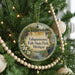 A circular ornament hanging on a Christmas tree, featuring a scenic image of Taquamenon Falls State Park in Michigan.