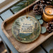 A wooden tray with a decorative ornament featuring a scenic landscape of Talcott Mountain State Park, Connecticut, and pine cones.