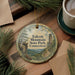 A decorative ornament featuring the name of a park, "Talcott Mountain State Park, Connecticut", surrounded by pine branches and a cup of coffee on a wooden surface.