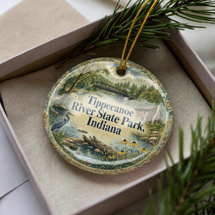 A decorative ornament in a box, featuring a scenic image of Tippecanoe River State Park, Indiana.
